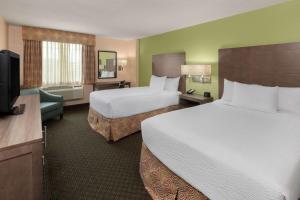 a hotel room with two beds and a flat screen tv at La Quinta by Wyndham San Antonio Medical Ctr. NW in San Antonio
