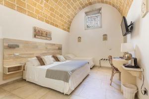 um quarto com uma cama e uma secretária num quarto em Clara Domus em Gallipoli