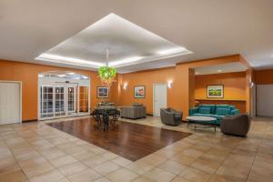 eine Lobby mit einem Sofa, einem Tisch und Stühlen in der Unterkunft La Quinta by Wyndham San Antonio Medical Ctr. NW in San Antonio