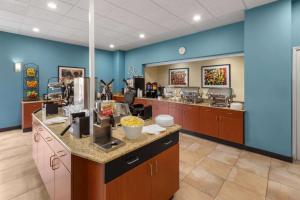 a cafeteria with blue walls and a food counter at La Quinta by Wyndham San Antonio Medical Ctr. NW in San Antonio