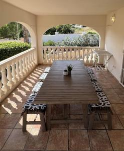 a wooden table on a patio with two chairs at Beauty 6-pers Villa Alfaz del pi in Cautivador