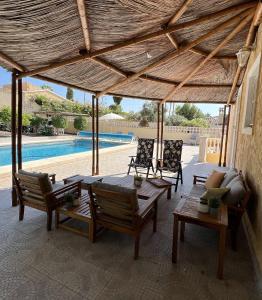 a patio with chairs and a table and a pool at Beauty 6-pers Villa Alfaz del pi in Cautivador