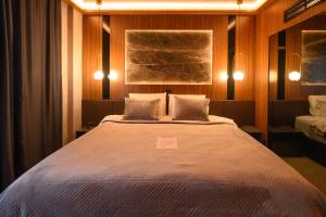 een slaapkamer met een groot bed met 2 kussens bij Hotel Macedonia Square in Skopje