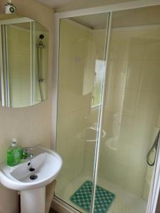 a bathroom with a sink and a shower at Cosy caravan Sunbeach in Llwyngwril