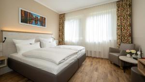 a bedroom with a large bed and a window at Hotel Rosengarten in Hamburg