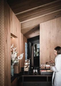 een vrouw die in een keuken staat om eten te bereiden bij Luxury Chalet Alpurio in Selva di Val Gardena