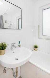 a white bathroom with a sink and a mirror at Kurzzeitglück 24h Self Check-In KR02 in Krefeld