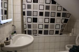 a bathroom with a sink and a shower curtain at Hirsch24- 4 Personen Apartment in Lippstadt