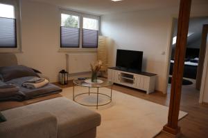 a living room with a couch and a tv at Hirsch24- 4 Personen Apartment in Lippstadt