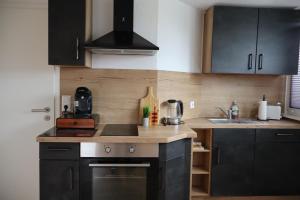 a kitchen with black cabinets and a counter top at Hirsch24- 4 Personen Apartment in Lippstadt