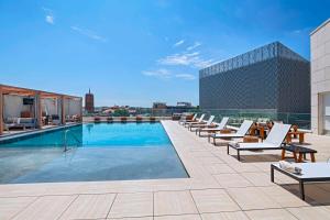 a pool on the roof of a building with lounge chairs at Thompson San Antonio - Riverwalk, by Hyatt in San Antonio
