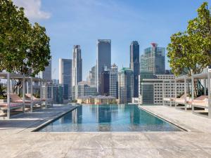 a swimming pool with a city skyline in the background at Mondrian Singapore Duxton in Singapore