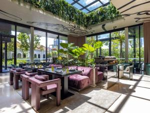 a restaurant with pink furniture and large windows at Mondrian Singapore Duxton in Singapore