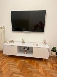 a white entertainment center with a flat screen tv on a wall at Apartman Nini in Kraljevo