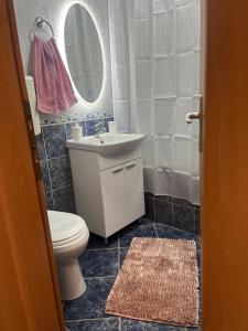 a bathroom with a toilet and a sink and a mirror at Apartman Nini in Kraljevo