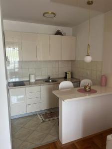 a kitchen with white cabinets and a counter top at Apartman Nini in Kraljevo