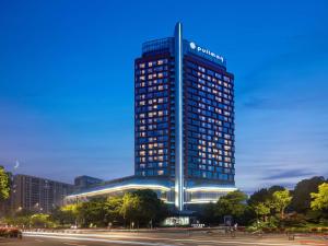 a tall blue building with lights on it at Pullman Haining in Haining