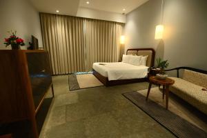 a hotel room with a bed and a couch at The Earth Amritsar, Trademark Collection by Wyndham in Amritsar