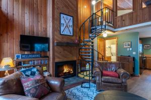 sala de estar con escalera y chimenea en 98 Elk Horn, en Whitefish