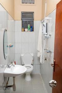 a white bathroom with a toilet and a sink at Mara Home Away in Lira, Uganda in Lira