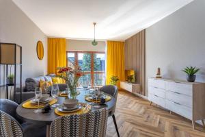 a living room with a dining room table with chairs at Apartament B3 Green Resort z Basenem, Sauną, Jacuzzi - 5D Apartments in Szklarska Poręba