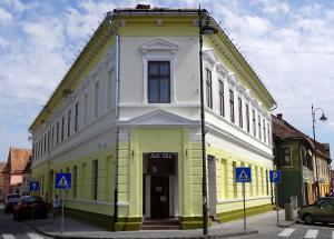 een geel en wit gebouw op de hoek van een straat bij Studio Sonia - Tordosan Central - #3 in Sibiu
