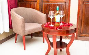 uma mesa com uma garrafa de vinho e dois copos em Comfort Inn Mbezi Beach em Dar es Salaam