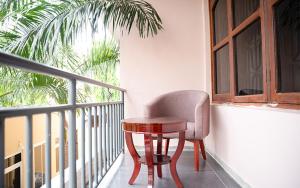 uma mesa e uma cadeira sentadas numa varanda em Comfort Inn Mbezi Beach em Dar es Salaam