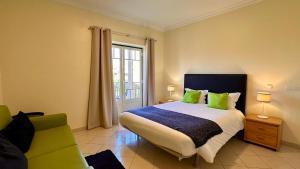 1 dormitorio con 1 cama y 1 sofá verde en Bicos R by Check-in Portugal, en Albufeira