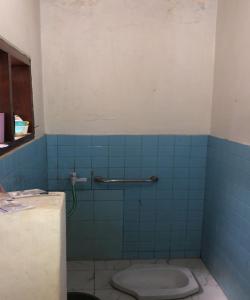 a bathroom with a toilet and a blue tile wall at OYO 93846 Gerlong Homestay in Bandung