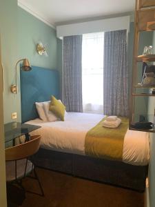 une chambre d'hôtel avec un lit et une fenêtre dans l'établissement Bloomsbury Palace Hotel, à Londres