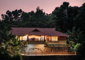 a house in the middle of a forest at night at Panchavati Villa in Manipala