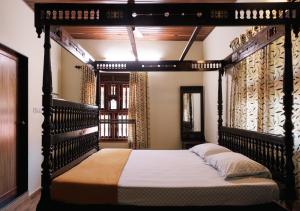 a bedroom with a canopy bed in a room at Panchavati Villa in Manipala