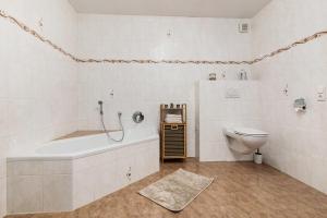 a white bathroom with a tub and a toilet at Ferienwohnung Obsthof Fieß in Oberkirch +21 photos