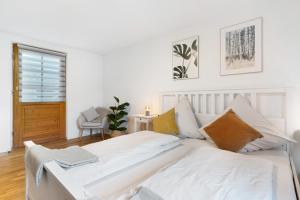 a white bedroom with a large white bed at Ferienwohnung Obsthof Fieß in Oberkirch