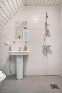 a white bathroom with a sink and a mirror at Villa Wolax in Kaarina