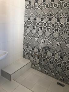 La salle de bains est pourvue d'une douche et d'un mur en carrelage. dans l'établissement Riad Malak, à Meknès
