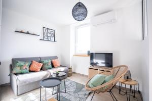 a living room with a couch and chairs and a tv at Escapade Ocean in Labenne