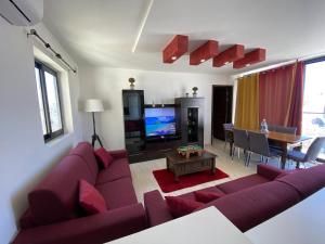 a living room with a purple couch and a table at XL Terrace Penthouse BBQ 200m From The Sea and Square in St Paul's Bay
