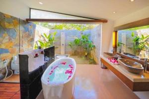 a bathroom with several sinks and a bath tub at Villa R331 Forest Flamingo Dai Lai Resort in Phúc Yên