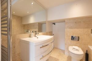 uma casa de banho com um lavatório branco e um WC. em Gorgeous loft style 3BR apt, Battersea em Londres