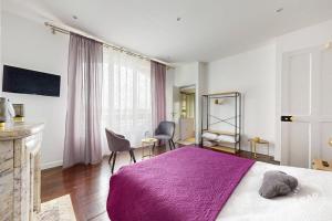 um quarto com uma cama com um cobertor roxo em Chambre dans un manoir au bord de l'Yonne près de Sens em Villeperrot