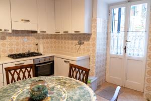 a kitchen with a table and a stove and a window at Posa in Santa Margherita Ligure