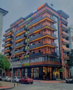 a tall building with cars parked in front of it at Graphic Hotel Batumi in Batumi