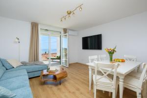 sala de estar con sofá azul y mesa en Hedera A9 en Dubrovnik