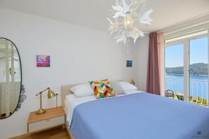 a bedroom with a bed and a large window at Hedera A9 in Dubrovnik