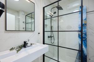 a bathroom with a shower and a sink and a mirror at Hedera A9 in Dubrovnik