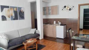 a living room with a couch and a kitchen at Apartman Andrić in Višegrad