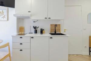 a kitchen with white cabinets and a counter top at Felp Santa Maria 1 in Setúbal