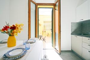 a kitchen with a table with plates and a vase of flowers at Martha's in Follonica